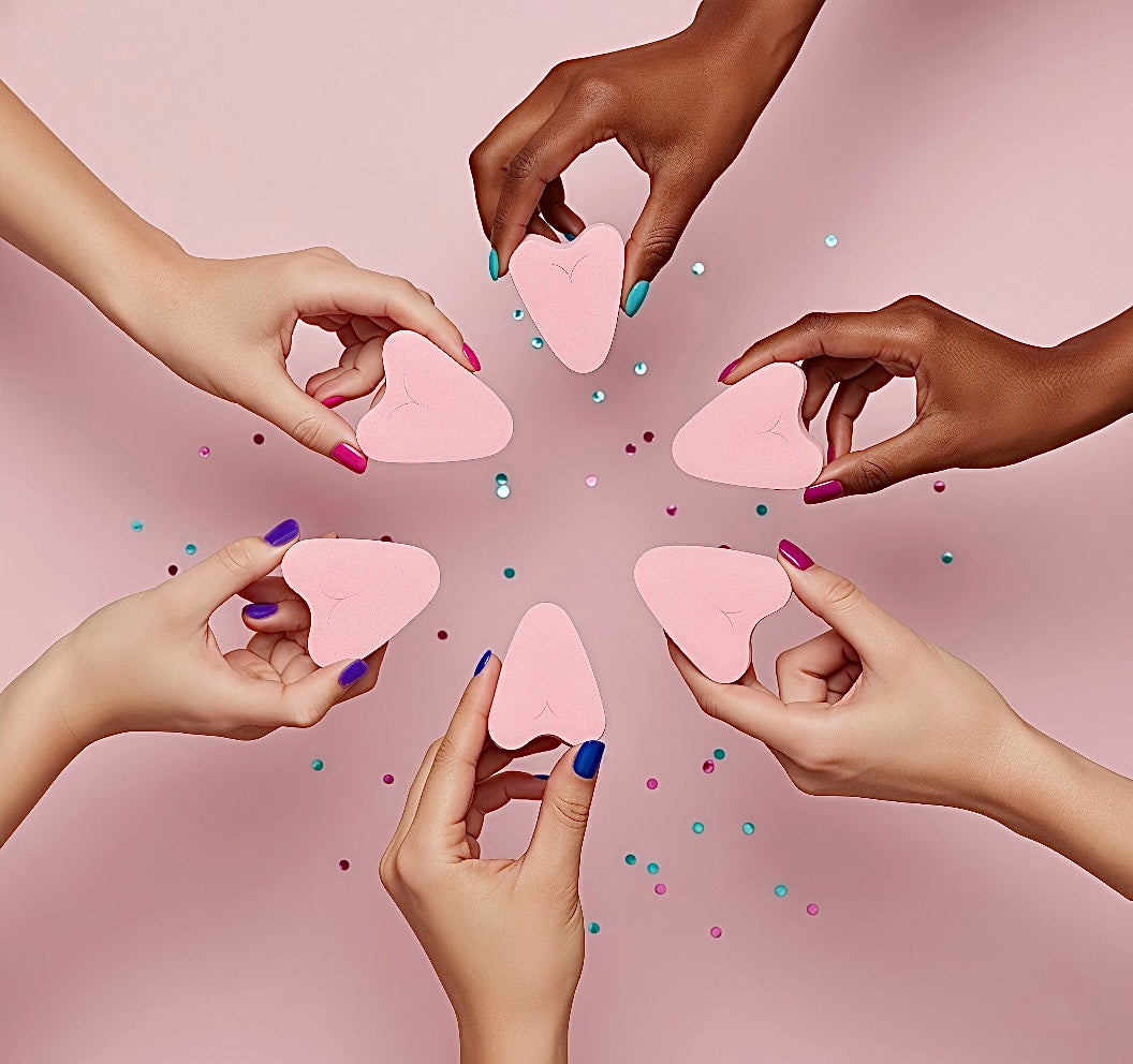 Multiple hands holding FemmeFlo menstrual sponges against a pink background